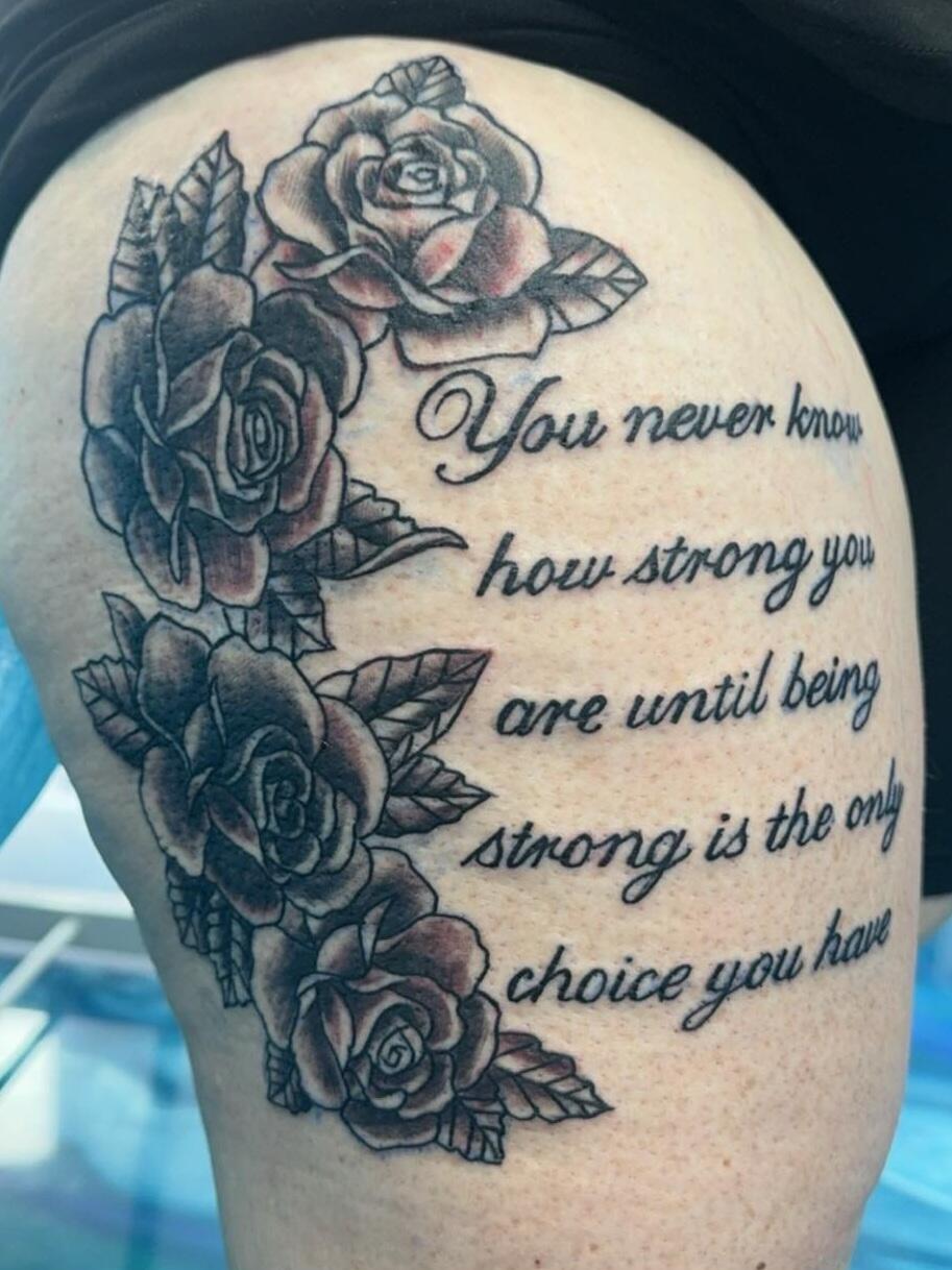 Black and grey rose tattoo with cursive lettering