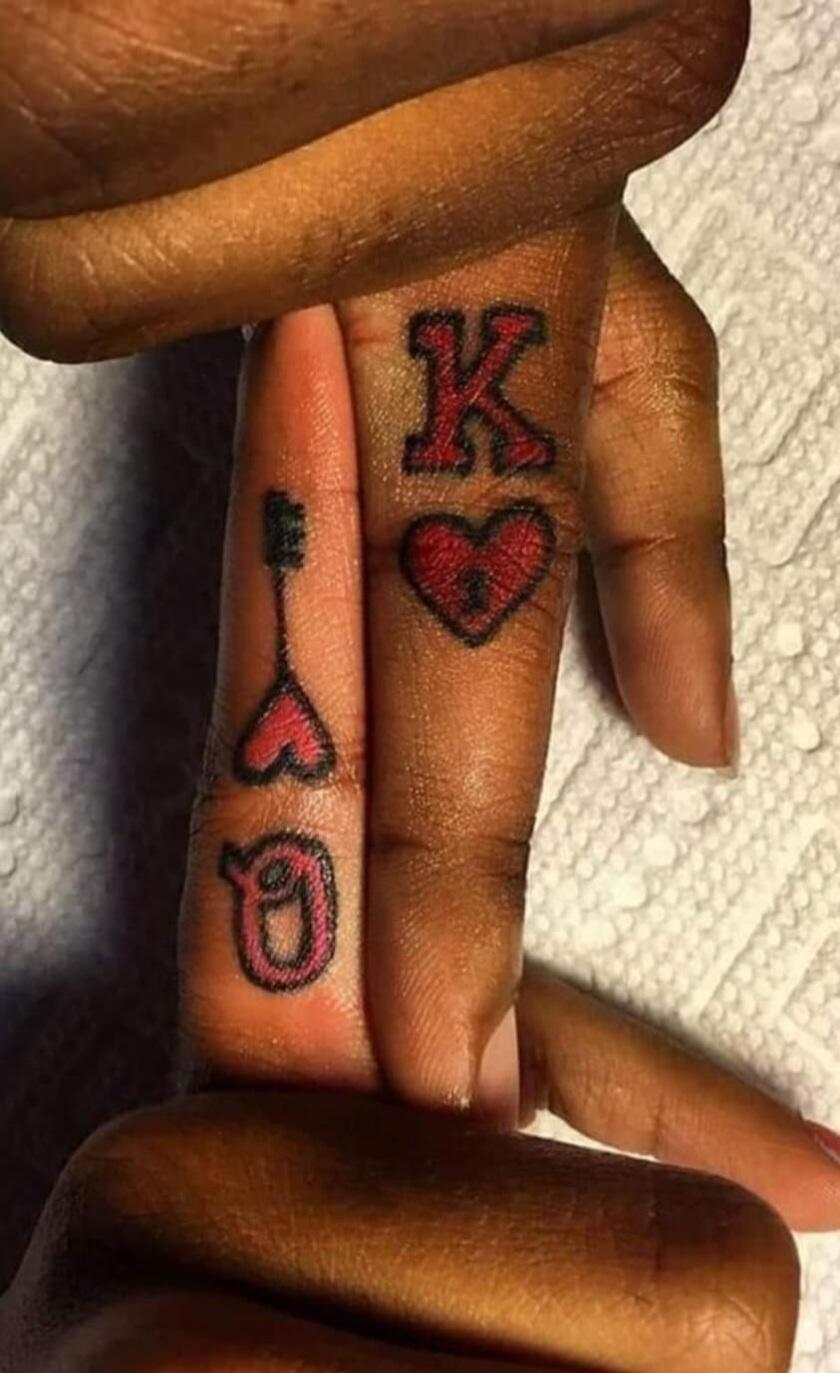 Matching king and queen playing-card tattoos with red hearts